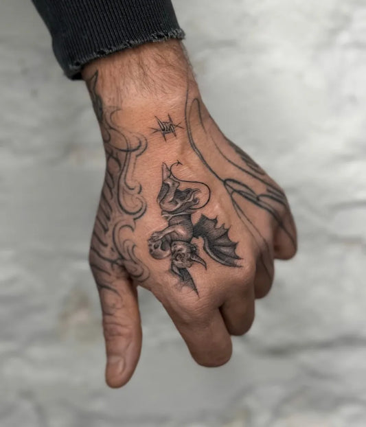Medium Black and Grey Cherub and Skull Tattoo on Men Hand by @xenia_tats