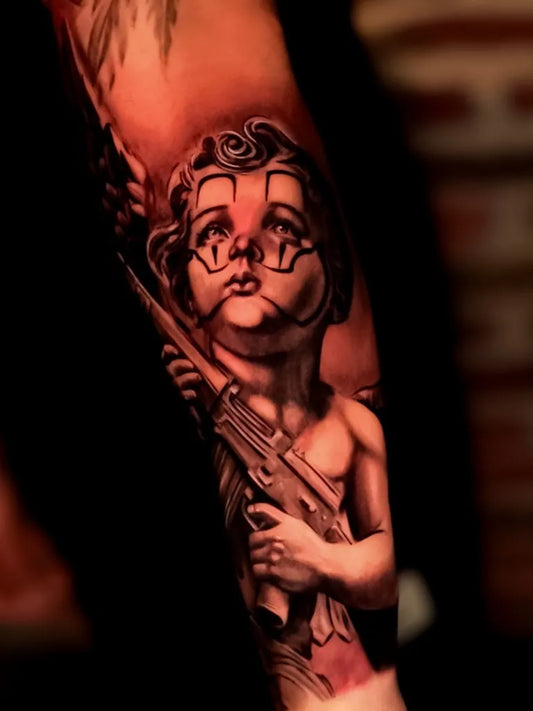 Medium Black and Grey Cherub with Gun Tattoo on Men Arm by @horusbriones