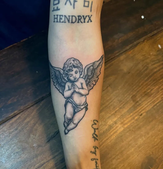 Medium Black and Grey Cherub with Script Tattoo on Men Arm by @live_to_the_max24
