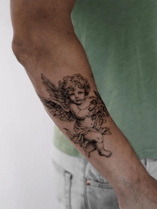 Medium Black and Grey Cherub with Wings Tattoo on Men Arm by @miri.tatts