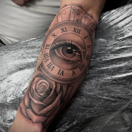 Medium Black and Grey Clock Eye Rose Tattoo on Men Arm by @nicofalascatattoo