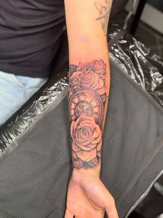 Medium Black and Grey Clock and Roses Tattoo on Men Arm by @whyusadnico.ttt
