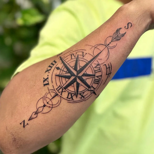Medium Black and Grey Compass with Arrow and Roman Numerals on Men Arm Tattoo by @inkscooltattoos