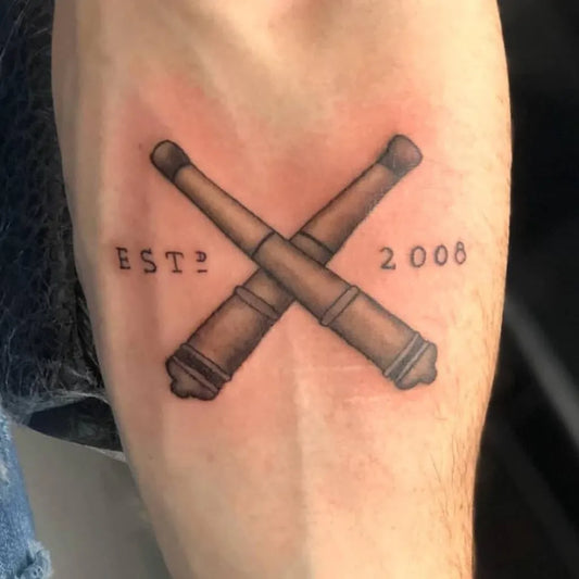 Medium Black and Grey Crossed Cannons Military Tattoo on Men Arm by @cherrysink21