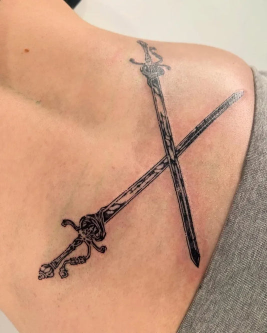 Medium Black and Grey Crossed Swords on Women Shoulder Tattoo by @clown.collegiate