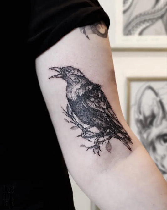 Medium Black and Grey Crow with Branch Tattoo on Women Arm by @grzegorczyk.tattoo