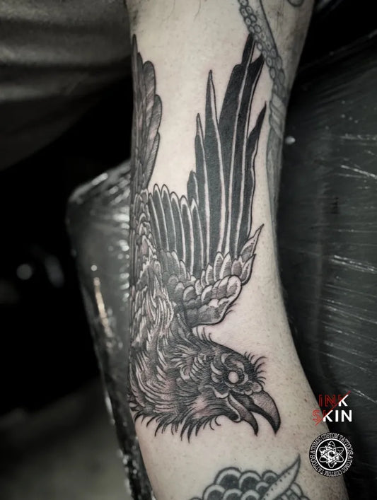 Medium Black and Grey Crow with Feathers Tattoo on Men Arm by @atomiccustomtattoos