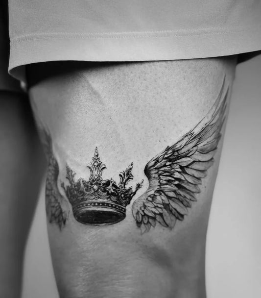 Medium Black and Grey Crown and Wings Tattoo on Men Thigh by @shan.6tattoo