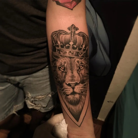 Medium Black and Grey Crowned Lion Tattoo on Women Arm by @alexisvargasart
