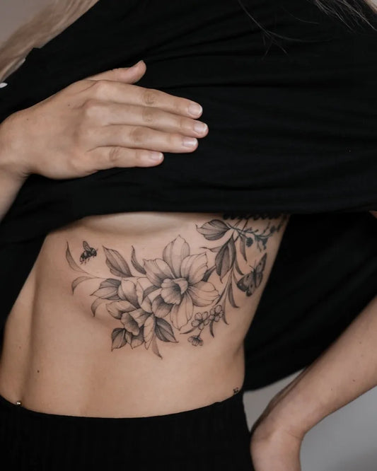 Medium Black and Grey Daffodil and Bee Tattoo on Women Rib by @betstattoo
