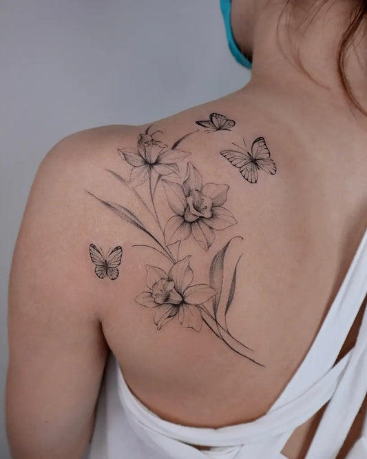 Medium Black and Grey Daffodil and Butterfly Tattoo on Women Shoulder by @mo_tattooist