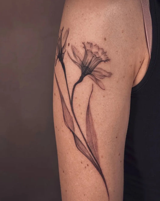Medium Black and Grey Daffodil and Leaves Tattoo on Women Arm by @cailintattoos
