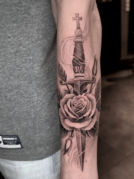 Medium Black and Grey Dagger and Rose Tattoo on Men Arm by @wisekidtattoo