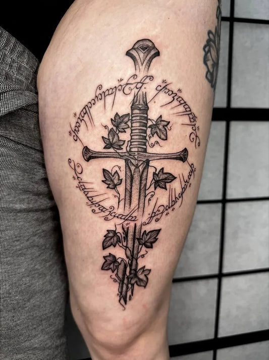 Medium Black and Grey Dagger with Elvish Script and Ivy Tattoo on Men Thigh by @jennybs_tattoo_goettingen
