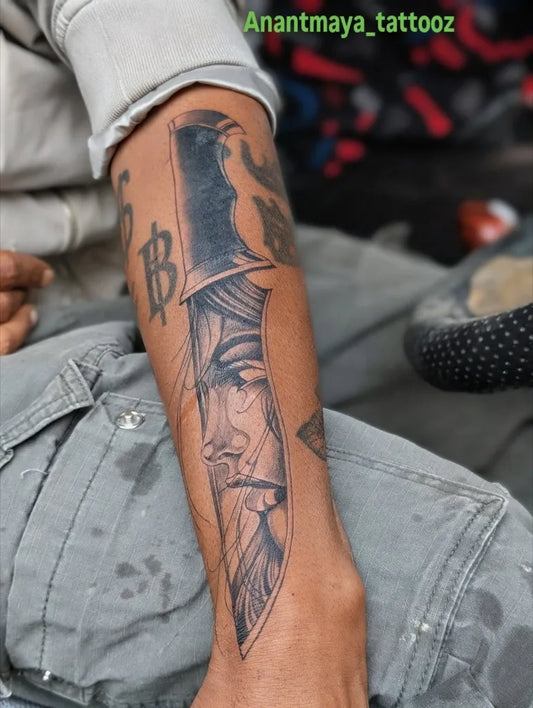 Medium Black and Grey Dagger with Face Tattoo on Men Arm by @anantmaya_tattooz