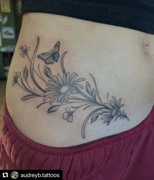 Medium Black and Grey Daisy and Butterfly Tattoo on Women Rib by @truetattoollc