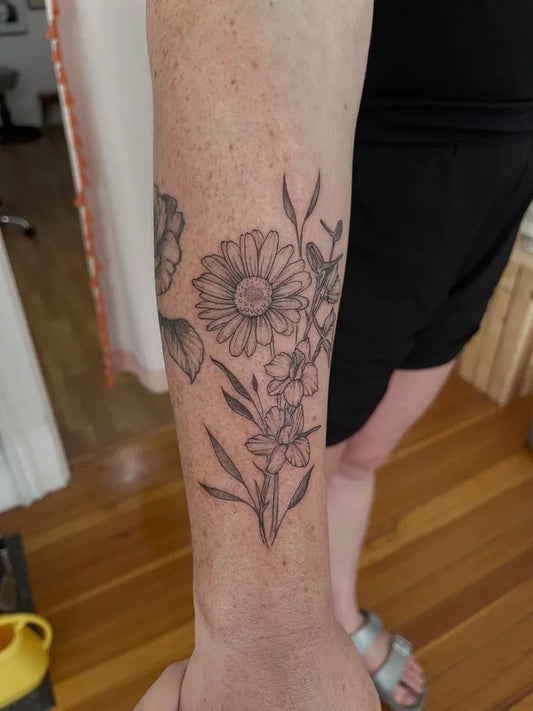 Medium Black and Grey Daisy and Gerbera Tattoo on Women Arm by @helloscoutie