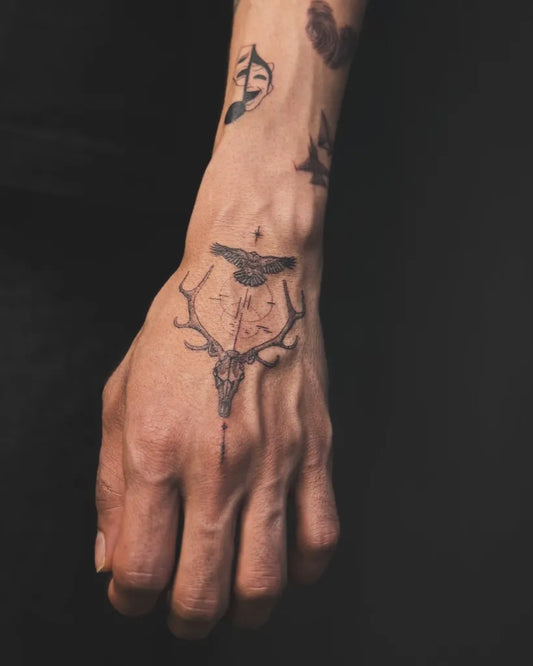 Medium Black and Grey Deer Skull and Cross Tattoo on Men Hand by @suntattoo_art