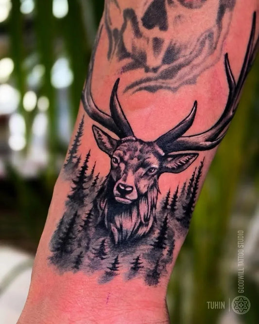 Medium Black and Grey Deer and Pine Trees Tattoo on Men Arm by @goodwilltattoostudio_bangalore