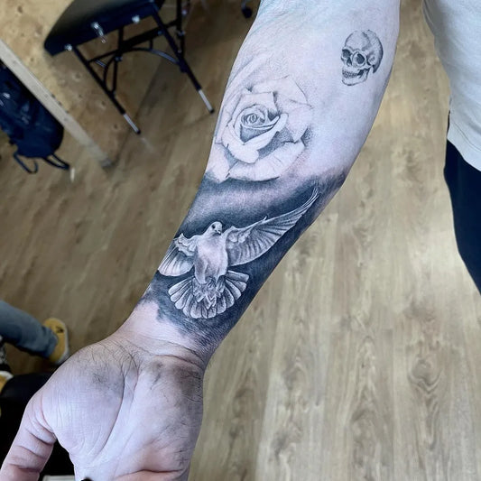 Medium Black and Grey Dove Rose and Skull Tattoo on Men Arm by @hugo_inkvault