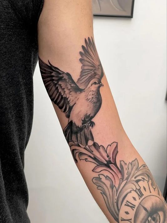 Medium Black and Grey Dove with Floral Elements Tattoo on Men Arm by @darioniccoli_tattoo