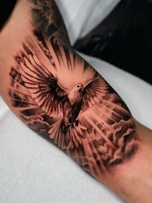 Medium Black and Grey Dove with Rays and Clouds Tattoo on Men Arm by @gionastaracetattoos