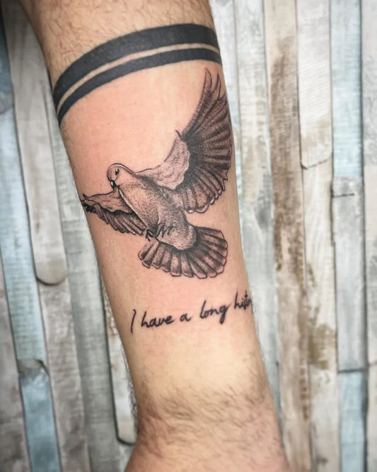 Medium Black and Grey Dove with Wings and Text Tattoo on Men Arm by @paulo_borrega