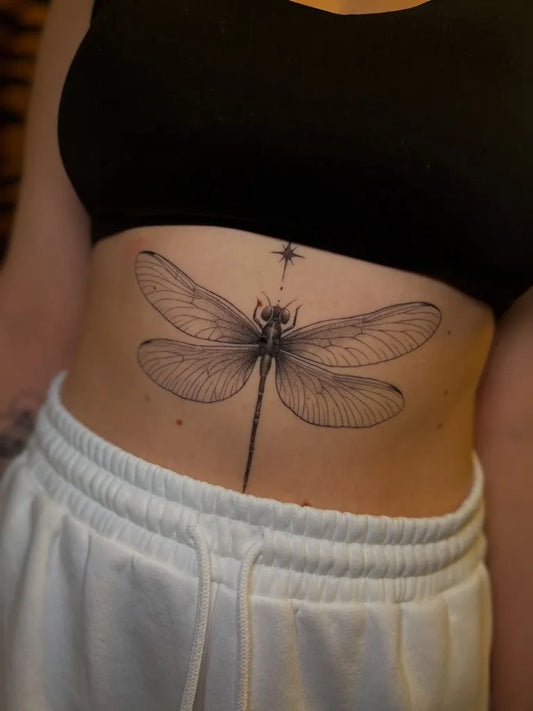 Medium Black and Grey Dragonfly with Star on Women Abdomen Tattoo by @jaris_ink