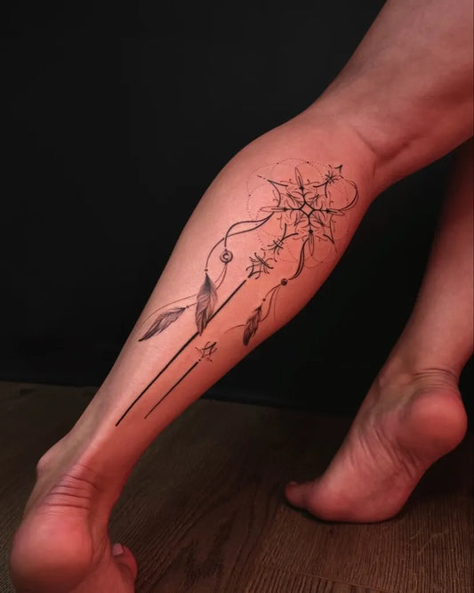 Medium Black and Grey Dream Catcher Feathers Tattoo on Women Leg by @sisters.tatt