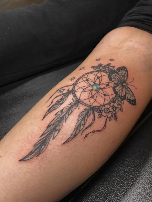 Medium Black and Grey Dream Catcher with Butterfly and Flowers Tattoo on Women Arm by @craneco_tattoo