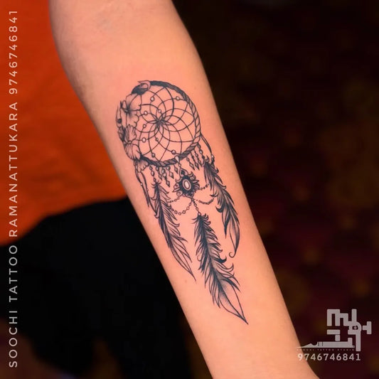Medium Black and Grey Dream Catcher with Feathers Tattoo on Women Arm by @soochi_tattoo
