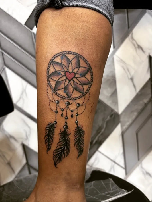 Medium Black and Grey Dream Catcher with Heart and Feathers Tattoo on Women Leg by @ashokatattoomumbai