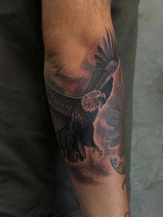 Medium Black and Grey Eagle with Flowers Tattoo on Men Arm by @byvinny