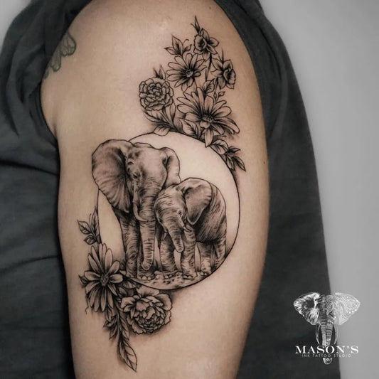 Medium Black and Grey Elephant and Flowers Tattoo on Women Shoulder by @masonsinkstudio_bali