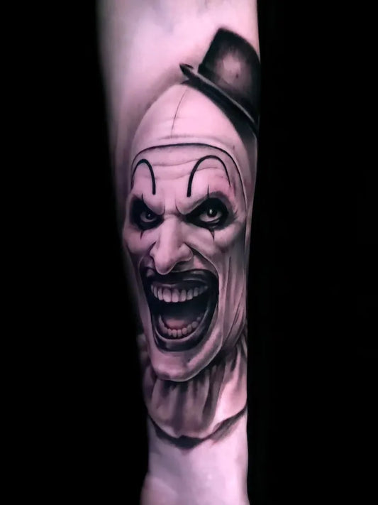 Medium Black and Grey Evil Clown Horror Tattoo on Men Arm by @angeloctopus.studio
