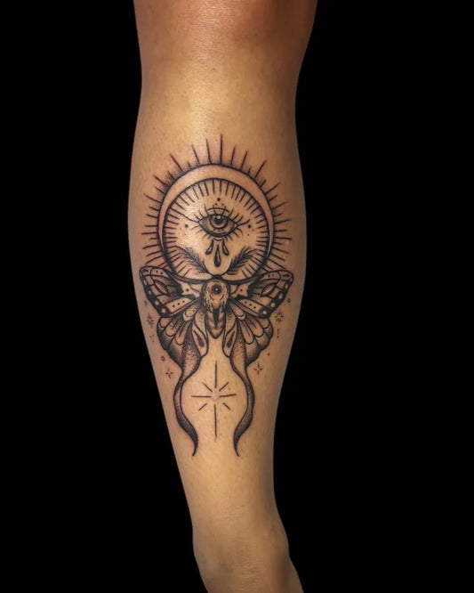 Medium Black and Grey Evil Eye Moth on Women Leg Tattoo by @kloe.cirsie.tattoos