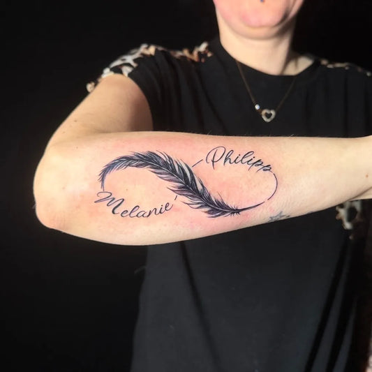 Medium Black and Grey Feather Infinity Names Tattoo on Women Arm by @eva.inks