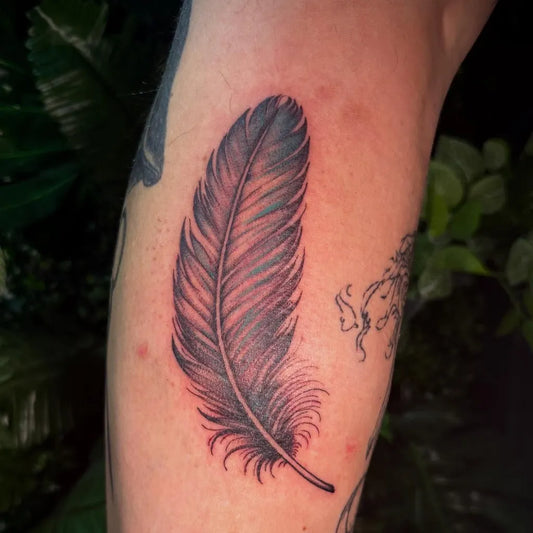 Medium Black and Grey Feather Tattoo on Men Arm by @snowy_tattoo