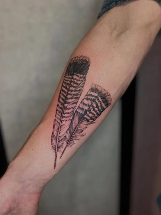 Medium Black and Grey Feather Tattoo on Men Arm by @zoeloutattoo