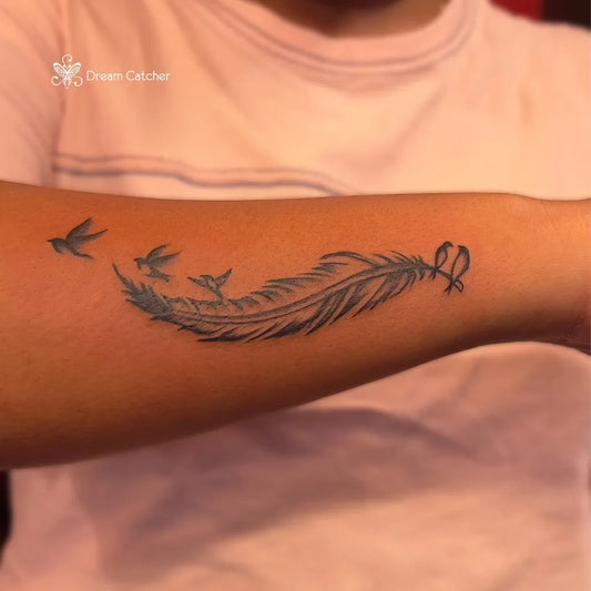 Medium Black and Grey Feather and Birds Tattoo on Women Forearm by @dreamcatcher_tattoos