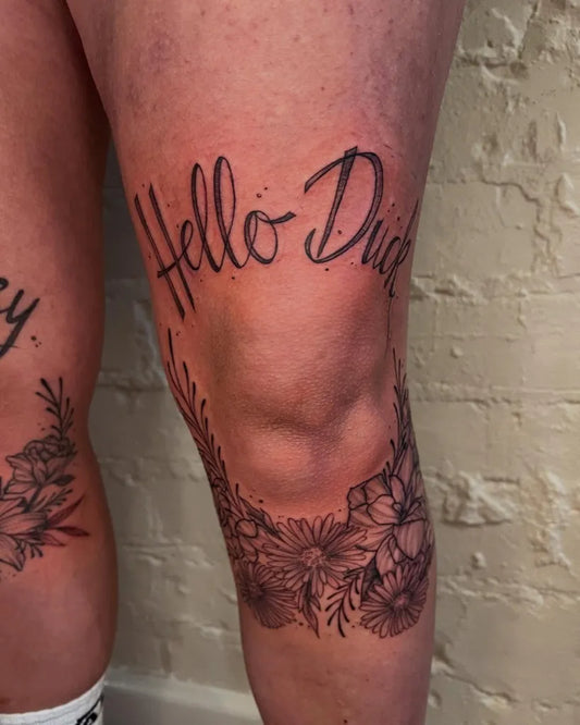 Medium Black and Grey Floral Script Tattoo on Women Knee by @redtillytattoo