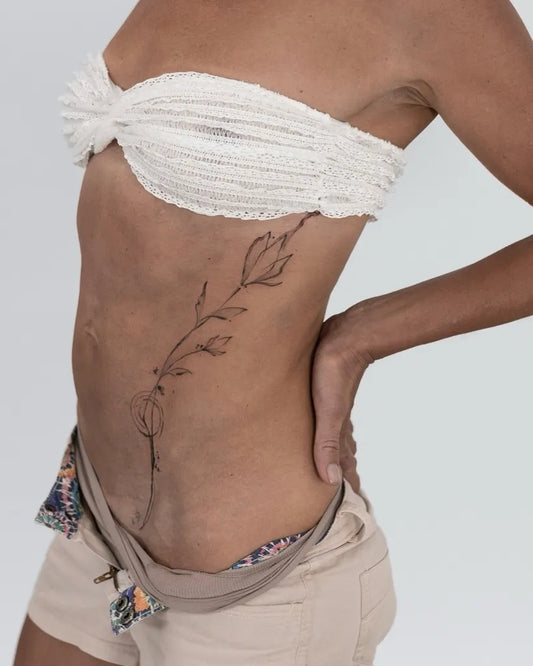 Medium Black and Grey Flowering Vine Tattoo on Women Rib by @loftn5tattoo_bali