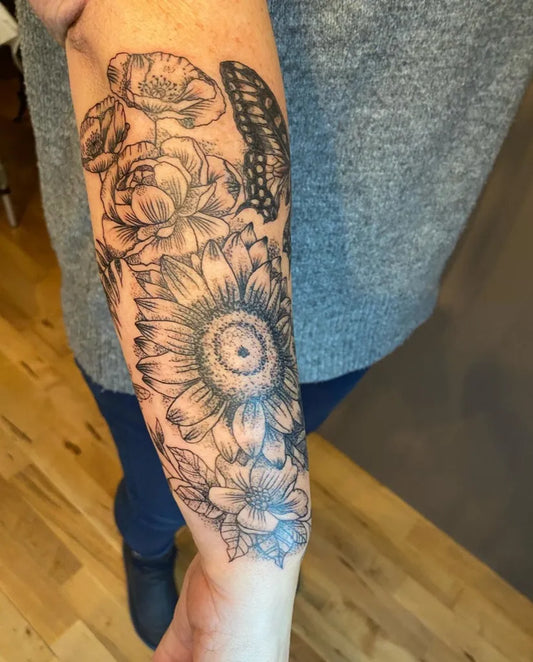 Medium Black and Grey Flowers and Butterfly Nature Tattoo on Women Arm by @sacred_grove_tattoo