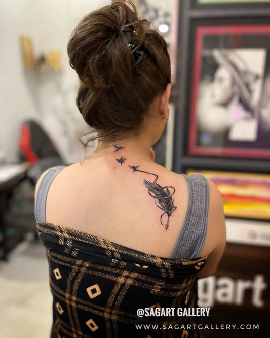 Medium Black and Grey Flying Birds and Feather Tattoo on Women Neck by @sagart_gallery