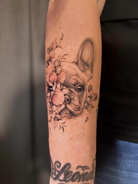Medium Black and Grey French Bulldog with Flowers Tattoo on Women Arm by @nala.ink