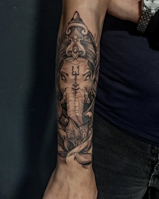 Medium Black and Grey Ganesha and Lotus Spiritual Tattoo on Men Forearm by @trickytattoo