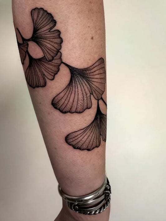 Medium Black and Grey Ginkgo Leaves Nature Tattoo on Women Arm by @luna_sea_tattoo