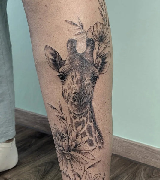 Medium Black and Grey Giraffe and Flowers Animal Tattoo on Women Leg by @arizona_ink_