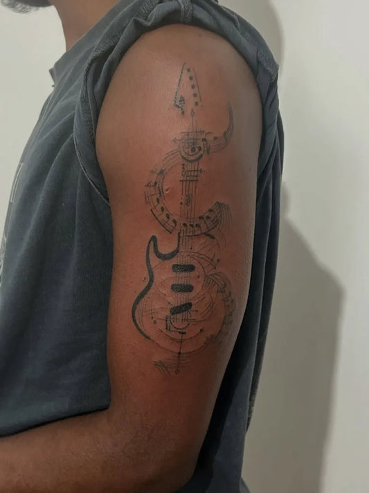Medium Black and Grey Guitar and Snake Music Tattoo on Men Arm by @art.h.ink_tattoos