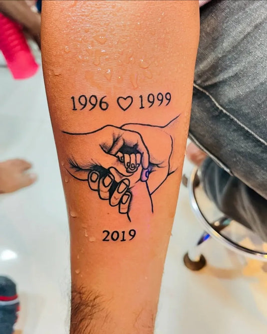 Medium Black and Grey Hands with Dates and Heart Family Tattoo on Men Arm by @nesh_tattoos